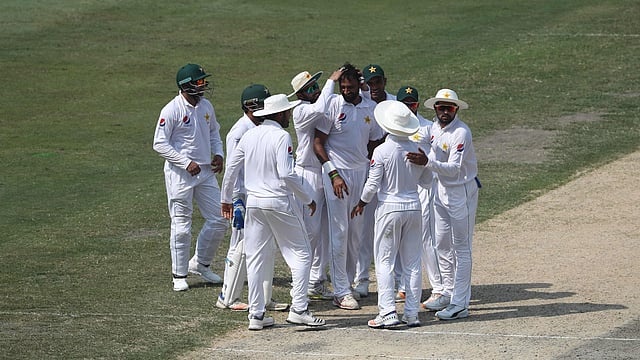 Pakistan cricketer Bilal Asif (C) celebrates with teammates after taking the wicket of Australian batsman Usman Khawaja during the third day of play of the first Test cricket match at the Dubai International Stadium in Dubai on 9 October 2018. Photo: AFP