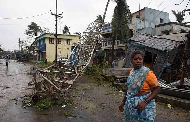 A woman stands next to a damaged communication tower after cyclone Titli hit in Srikakulam district in the southern state of Andhra Pradesh, India on 11 October, 2018. Photo: Reuters