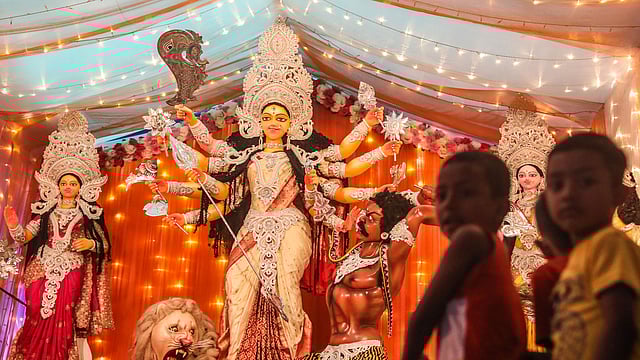 Children before the idol of goddess Durga at a mandap in Goalnagar in Old Dhaka.