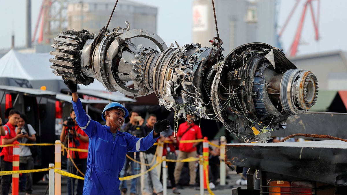 A worker assists his colleague as an turbine engine of Lion Air flight JT610 is lifted up at Tanjung Priok port in Jakarta. Photo: Reuters