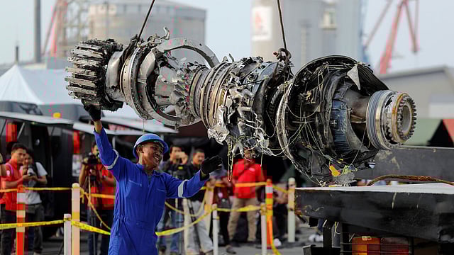 A worker assists his colleague as an turbine engine of Lion Air flight JT610 is lifted up at Tanjung Priok port in Jakarta. Photo: Reuters