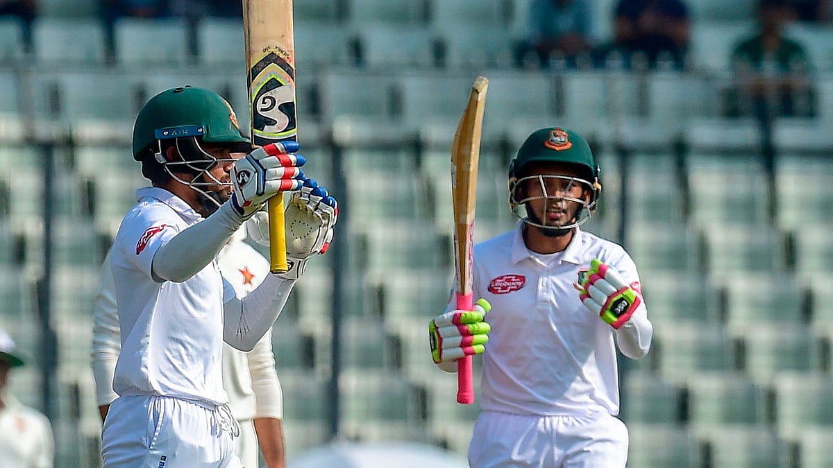 Bangladesh cricketer Mominul Haque (L) celebrates his century as his teammate Mushfiqur Rahim (R) looks on during the first day of the second Test cricket match between Bangladesh and Zimbabwe at the Sher-e-Bangla National Cricket Stadium in Dhaka on 11 November 2018. Photo: AFP