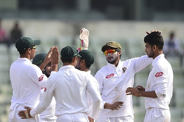 Bangladeshi cricketer (2R) Shakib Al Hasan congratulates Nayeem Hasan (R) after the dismissal of the West Indies cricketer Shane Dowrich during the third day of the second Test cricket match between Bangladesh and West Indies at the Sher-e-Bangla National Cricket Stadium in Dhaka on 2 December 2018. -- Photo: AFP