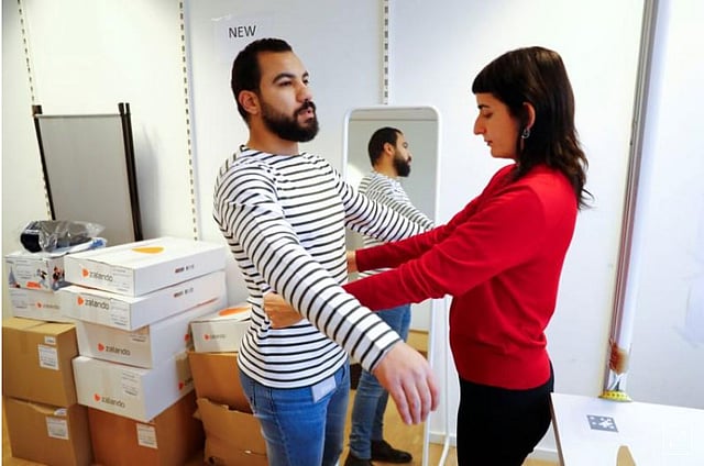 Fitting models checks out sizes of a t-shirt which goes on sale at the online shop of fashion retailer Zalando in Berlin, Germany, on 17 December 2018. -- Photo: Reuters