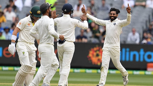 India`s Ravindra Jadeja (R) celebrates taking a wicket of Australia`s batsman Marcus Harris (L) with teammates during day four of the third cricket Test match between Australia and India in Melbourne on 29 December 2018. Photo: AFP