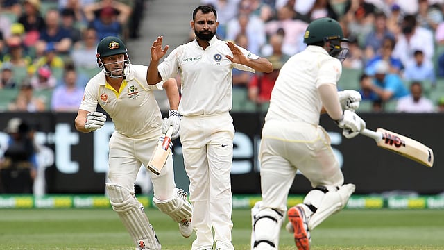Australia`s batsmen Shaun Marsh (L) Travis Head (R) run between the wickets as India`s paceman Mohammed Shami looks on during day four of the third cricket Test match between Australia and India in Melbourne on 29 December 2018. Photo: AFP