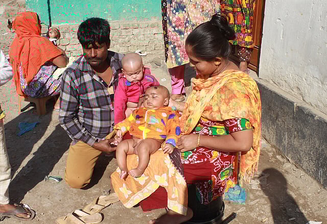 Parents are seen basking in the winter morning sun in the Malgudam area of Mymensingh on 31 December. Photo: Anwar Hossain