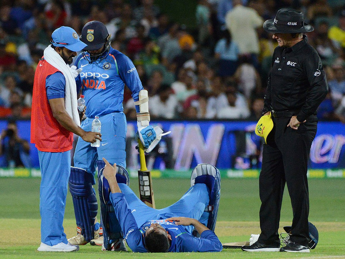 Indian batsman Mahendra Singh Dhoni (C) lies on the pitch as a team medic checks on him during the second one-day international cricket match between Australia and India at the Adelaide Oval on 15 January 2019. -- Photo: AFP