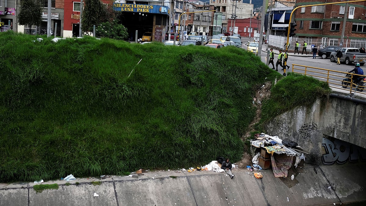 A man, who lives next to a canal, sits next to his makeshift house in Bogota, Colombia on 19 May 2018. Photo: Reuters