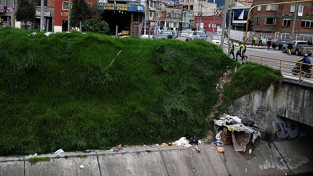 A man, who lives next to a canal, sits next to his makeshift house in Bogota, Colombia on 19 May 2018. Photo: Reuters