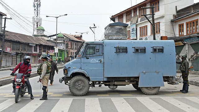 Indian paramilitary troopers stop a motorcyclist as they block a road in Srinagar on 1 March, 2019. Photo: AFP