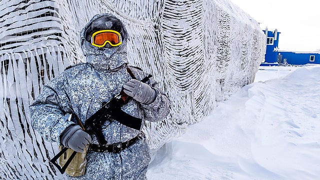 A soldier holds a machine gun as he patrols the Russian northern military base on Kotelny island, beyond the Artic circle