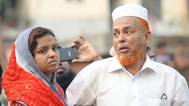 Two people watch as around 50 shops at Malibagh kitchen market gutted in fire on 18 April. Photo: Abdus Salam