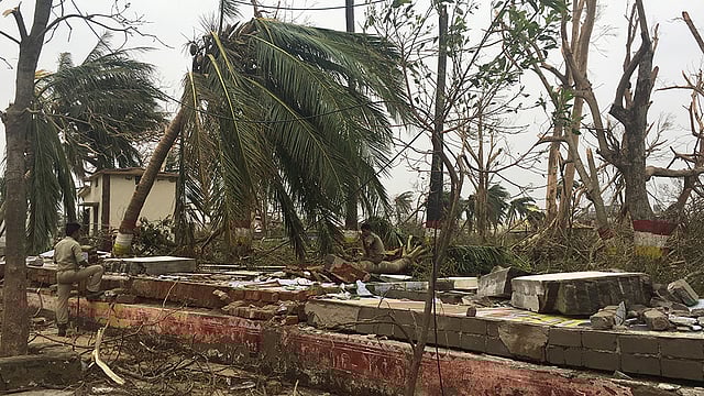 A police officer rests as he sits on a damaged wall following Cyclone Fani in Puri, in the eastern state of Odisha, India, 5 May, 2019. Photo: AFP