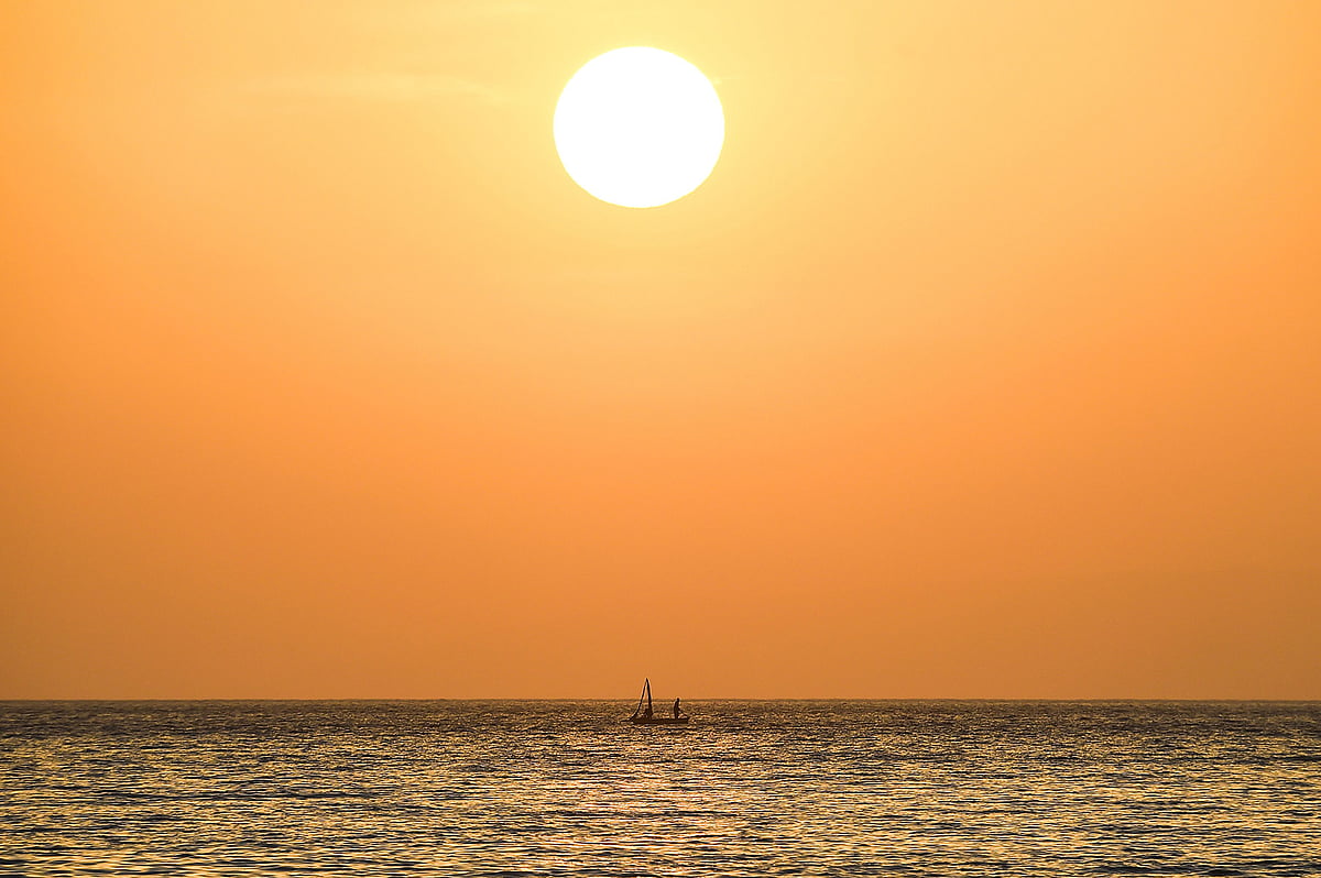 A fishermen stands on his boat under the setting sun on the Caribbean sea off the coast of Port-au-Prince, on 14 May 2019. Photo: AFP