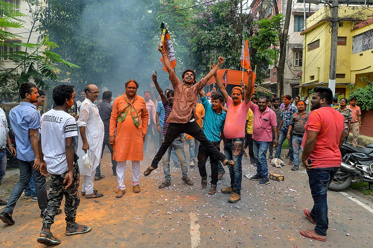 An Indian supporter of Bharatiya Janata Party (BJP) jumps in the air as he celebrates along with others on the vote results day for India`s general election in Siliguri on 23 May 2019. AFP