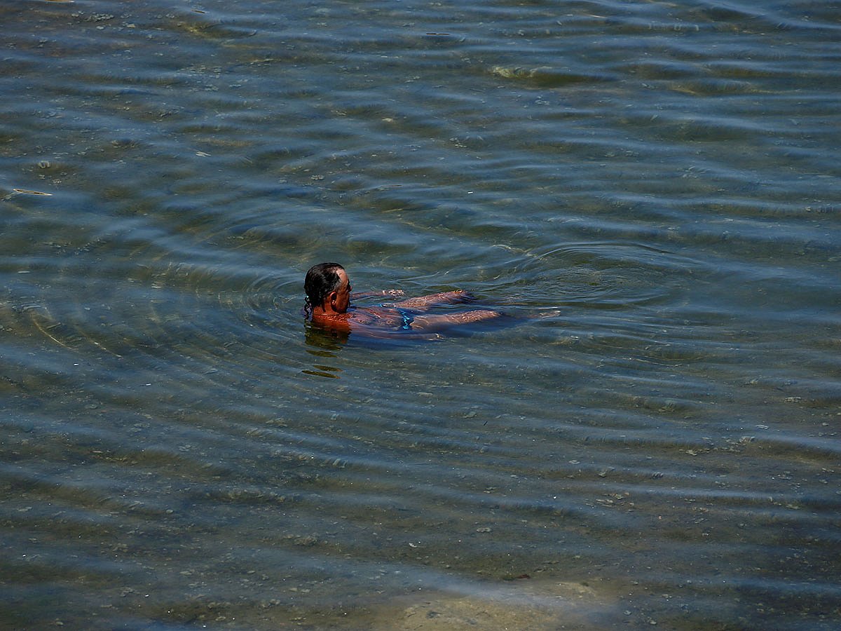A man sits in a rock pool by the sea as a heatwave hits Europe, in Sliema, Malta on 26 June. Photo: Reuters