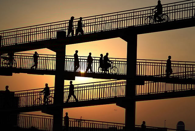 Asian labourers cross a pedestrian bridge in Dubai on 7 August 2019, as they head to work at a vegetable market. Photo: AFP