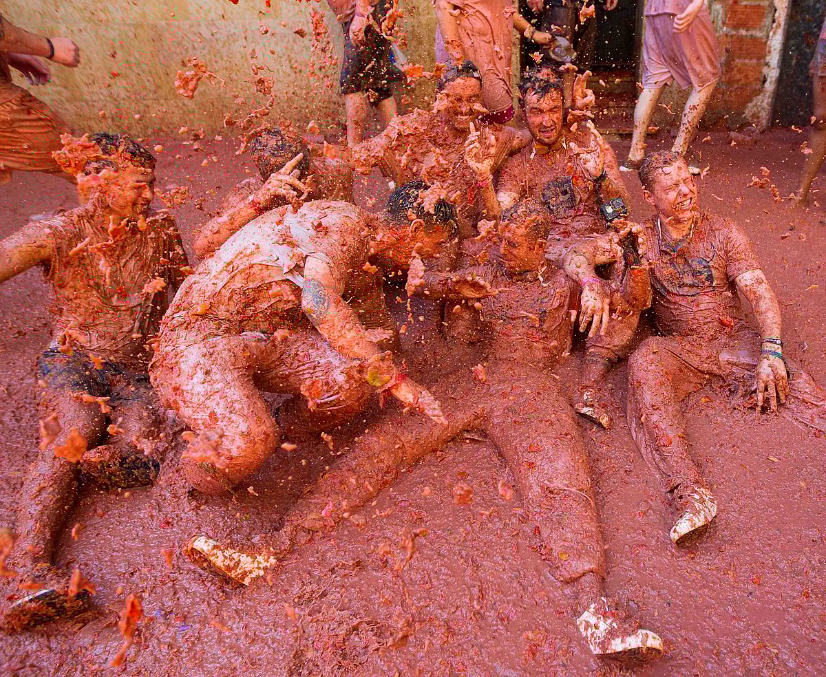 Revellers covered in tomato pulp take part in the annual `Tomatina` festival in the eastern town of Bunol, on 28 August 2019. Photo: AFP