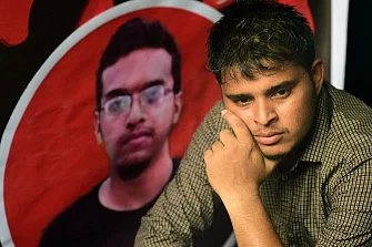 A Bangladeshi student sits during a protest in Dhaka on 7 October 2019, next to a portrait of Abrar Fahad, who was allegedly beaten to death by ruling party activists. Photo: AFP