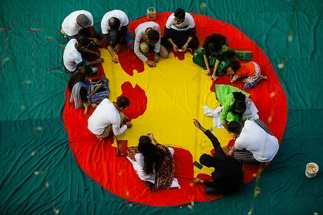 Students sew a flag in a programme `Amar Bhalobasar Pataka` on the eve of the Victory Day of Bangladesh at Shantir Payra Chattar at Dhaka University on 14 December 2019. Photo: Dipu Malakar
