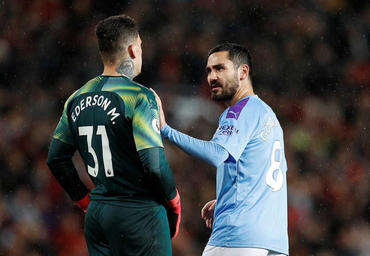 Manchester City's Ilkay Gundogan (R) with Ederson. File Photo: Reuters