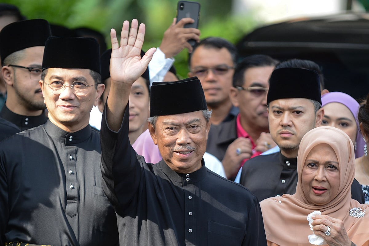 This handout from Malaysia's information department taken and released on 1 March 2020 shows Malaysia's incoming prime minister Muhyiddin Yassin (C) waving outside his residence in Kuala Lumpur before his swearing-in ceremony as the country's new leader. Photo: AFP