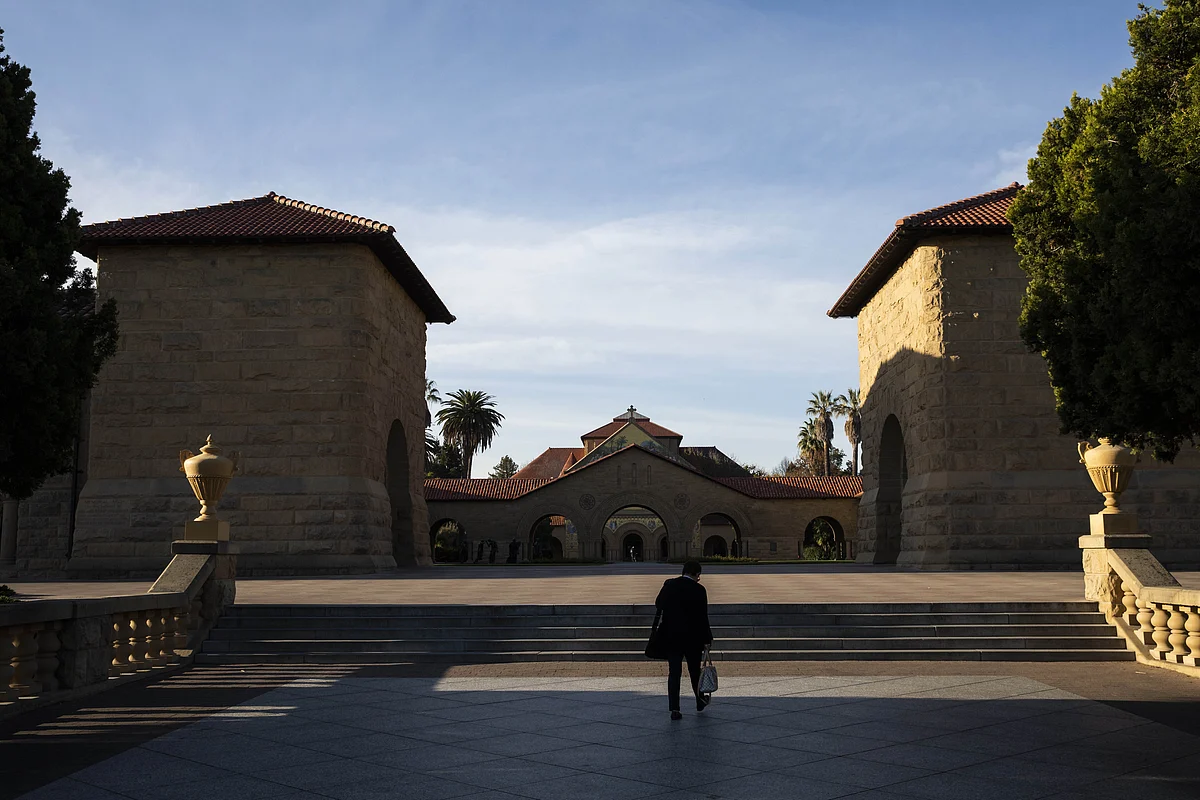 A person walks towards the main quad during a quiet morning at Stanford University on 9 March 2020 in Stanford, California. Stanford University announced that classes will be held online for the remainder of the winter quarter after a staff member working in a clinic tested positive for the Coronavirus.