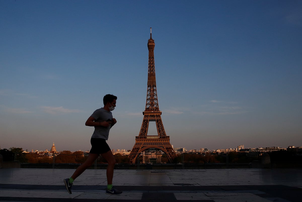 A man runs wearing a protective face mask in front of the Eiffel Tower during a lockdown imposed to slow the spread of the coronavirus disease (COVID-19), in Paris, France on 8 April.