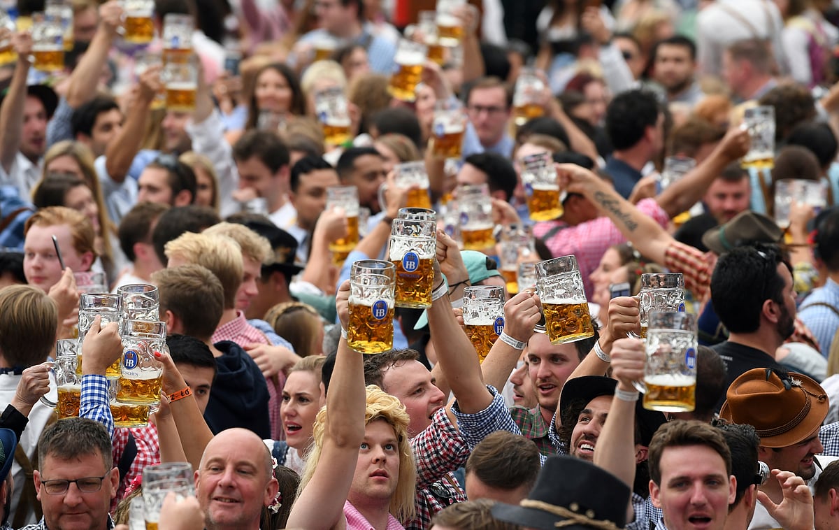 People cheer with the pints of beer at the opening day of the 186th Oktoberfest in Munich, Germany in 2019.