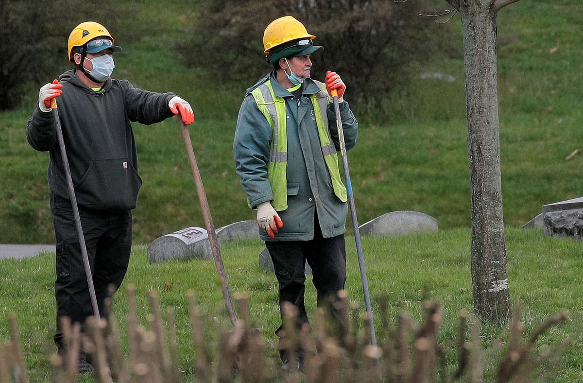 Workers watch as funerals take place at The Green-Wood Cemetery, amid the coronavirus disease (COVID-19) outbreak in the Brooklyn, New York, US, on 9 April 2020