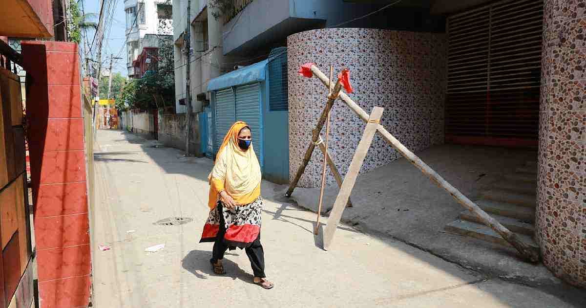 A woman walks along a street in Dhaka