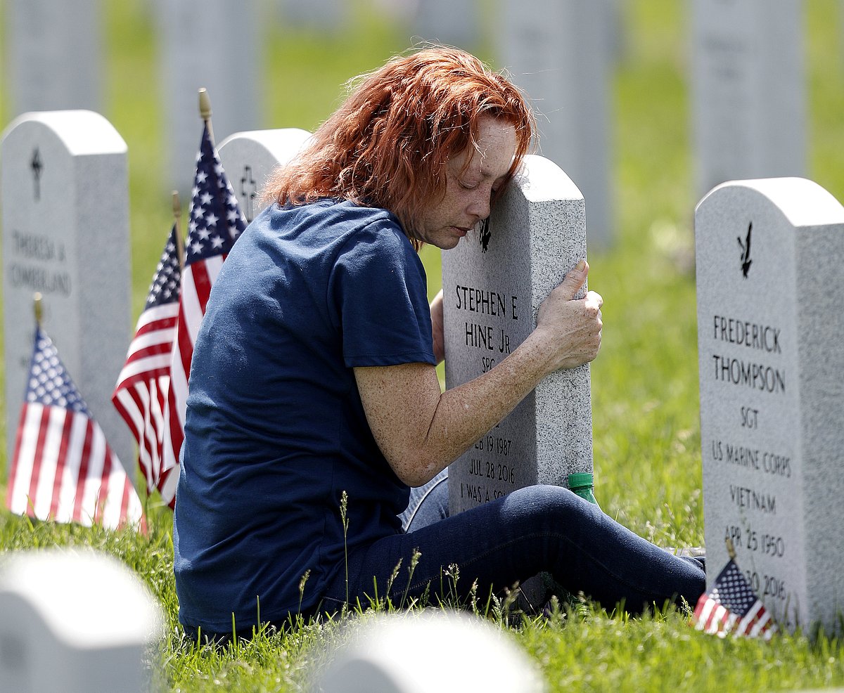 Maria Velez of Orlando, Florida, hugs the tombstone of her son Stephen at the Ohio Western Reserve National Cemetery on Memorial Day, during the global outbreak of the coronavirus disease (COVID-19), in Seville, Ohio, US on 25 May 2020