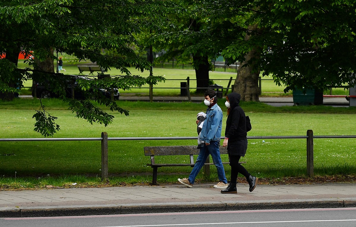 People wearing masks walk in Clapham Common, following the outbreak of the coronavirus disease (COVID-19), London, Britain on 3 May.