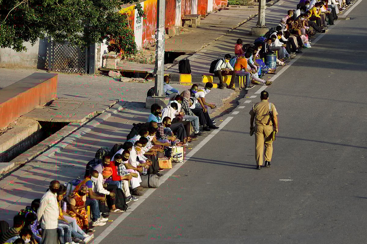 Migrant workers and their families wait for transport to reach to a railway station to board trains to their home state of eastern Bihar, after a limited reopening of India's giant rail network following a nearly seven-week lockdown to slow the spreading of the coronavirus disease (COVID-19), in Noida, India, on 16 May 2020