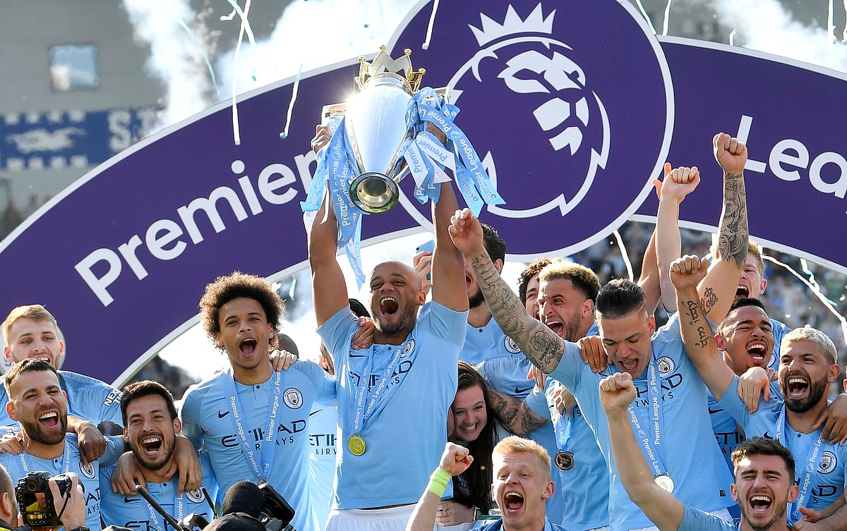 Manchester City skipper Vincent Kompany lifts the trophy as they celebrate defending the Premier League title following a 4-1 victory at Brighton & Hove Albion on 12 May 2019