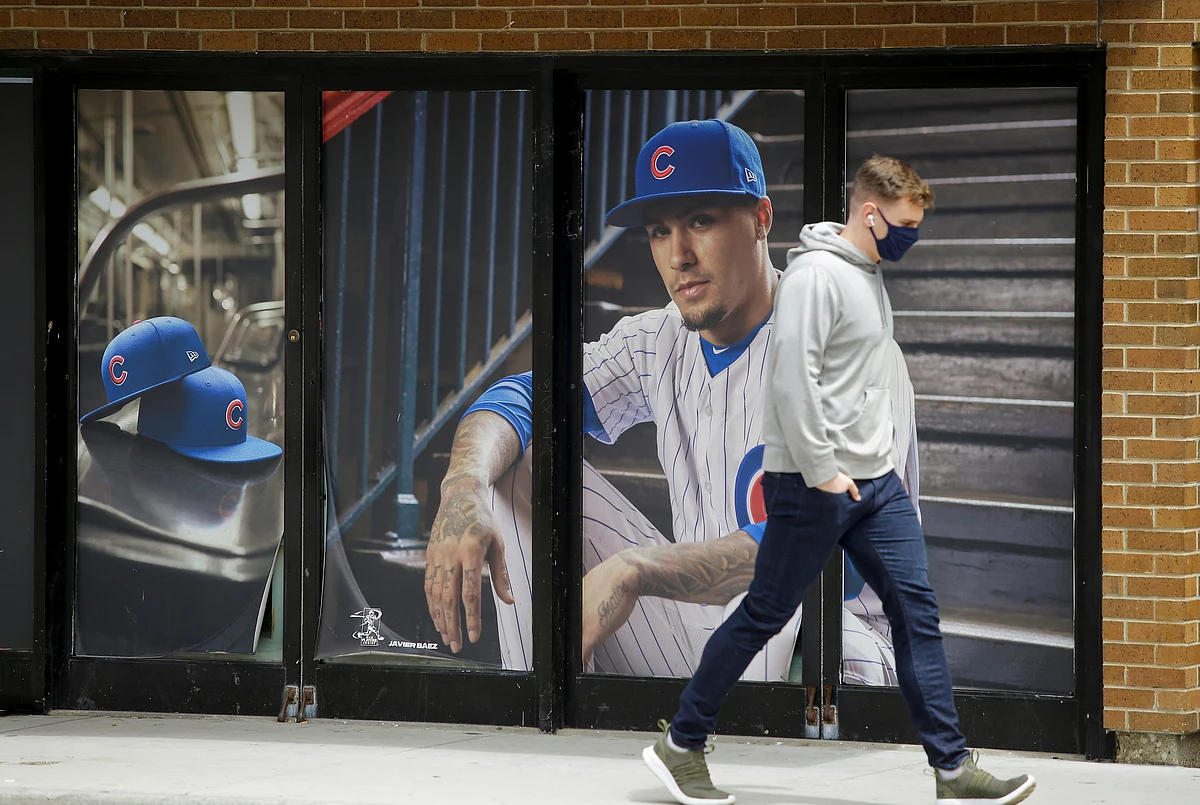 A pedestrian walks past a photo of Chicago Cubs player Javier Baez in the Wrigleyville neighborhood near the Chicago Cubs home stadium of Wrigley Field, which has been closed due to the coronavirus disease (COVID-19) restrictions in Chicago, Illinois, US on 20 May.
