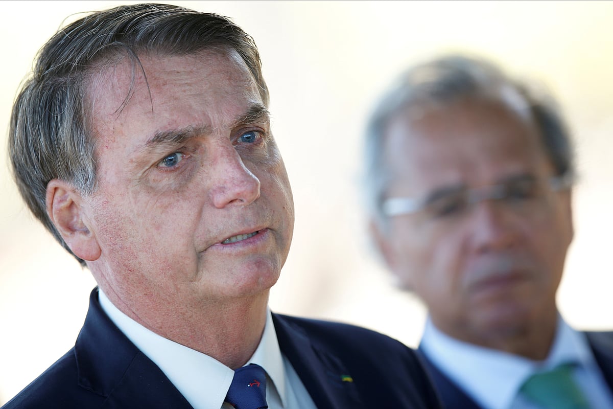 Brazil's President Jair Bolsonaro speaks near Brazil's Economy Minister Paulo Guedes while leaving Alvorada Palace in Brasilia, Brazil, 27 April 2020.