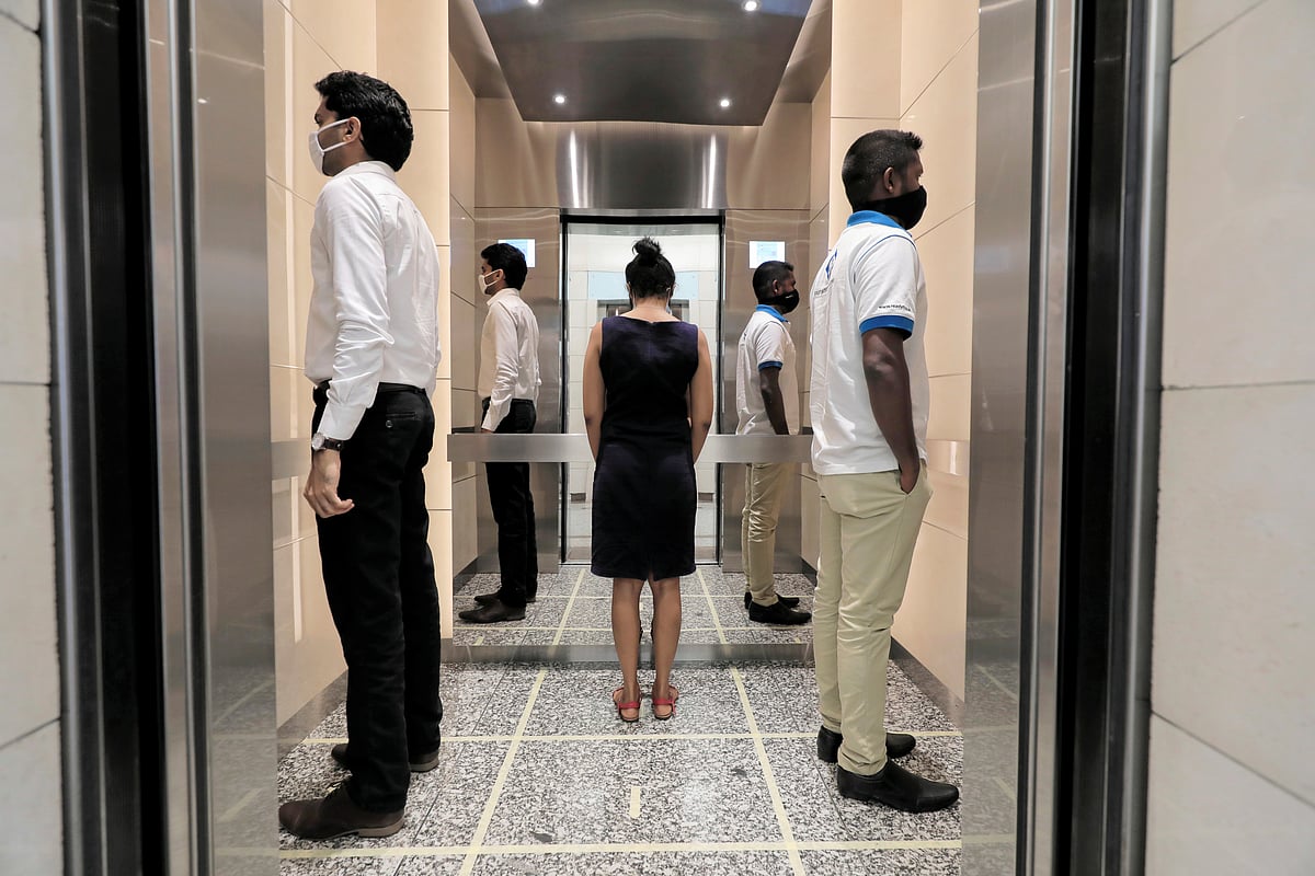 People practice social distancing inside an elevator prior arriving to their work places at World Trade Center, after the government announced that private and state companies will reopen their offices after almost two months of lockdown amidst concerns about the spread of coronavirus disease (COVID-19) in Colombo, Sri Lanka 11 May 2020.