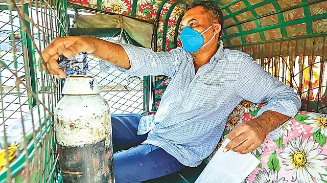 People rush to the Linde Bangladesh plant in Tejgaon to fill oxygen cylinders. This man has collected oxygen for a patient in a hospital at Nikunja in the capital city and is returning by CNG-run auto-rickshaw.
