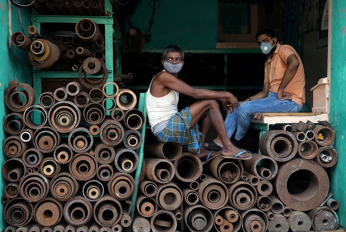Workers wearing protective face masks sit inside a shop selling iron pipes at a wholesale iron market, after authorities eased lockdown restrictions that were imposed to slow the spread of the coronavirus disease (COVID-19), in Kolkata, India on 15 June.
