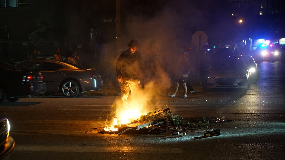 A protestor stands near a fire on the street during a protest against the death in Minneapolis police custody of African-American man George Floyd, in St Louis, Missouri, US, 2 June 2020.