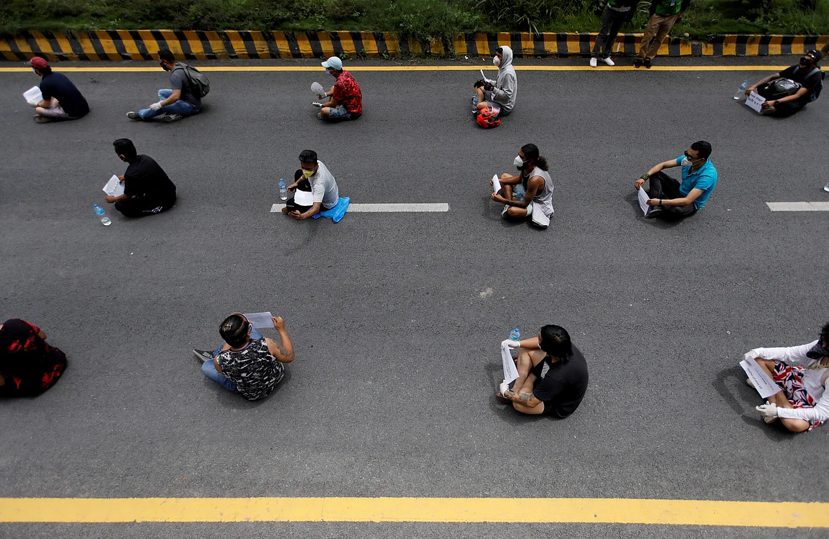 Nepalese youths holding placards maintain social distance as they take part in a protest demanding a more effective government response to the coronavirus outbreak, in Kathmandu, Nepal, 13 June.