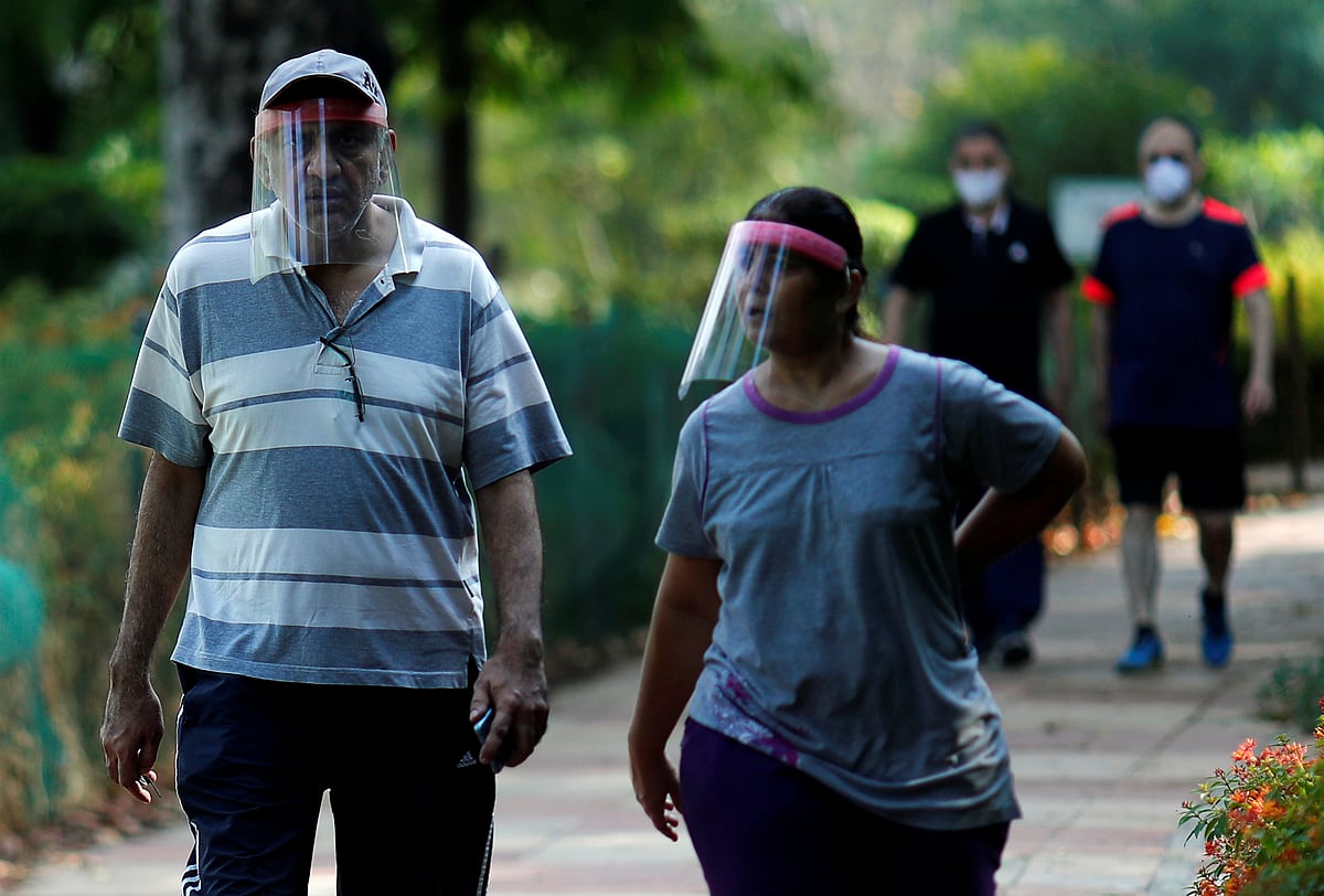 People wearing protective face shields walk inside a park after few restrictions were lifted, during an extended nationwide lockdown to slow the spread of the coronavirus disease (COVID-19), in New Delhi, India on 31 May.
