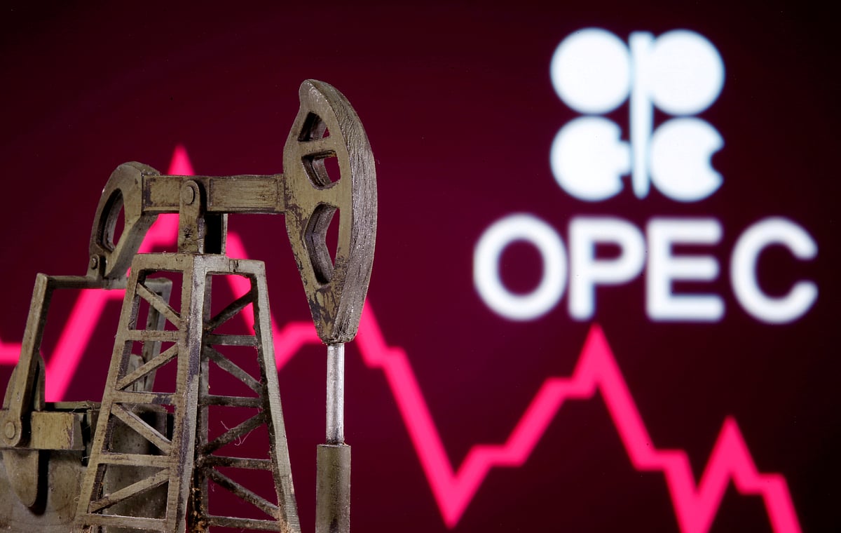 A 3D printed oil pump jack is seen in front of displayed stock graph and Opec logo in this illustration picture on 14 April.