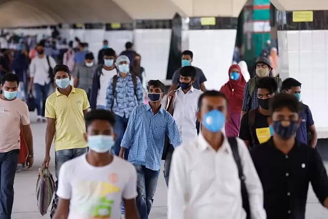 People walk wearing masks in Dhaka.