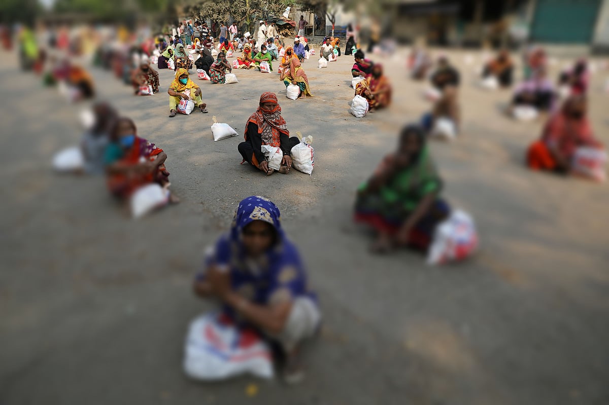 A representational image. Women sit on the ground maintaining social distance waiting to receive relief supplies in Dhaka on 2 April 2020.