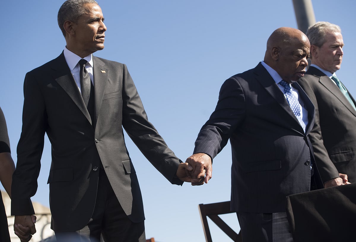 In this file photo taken on 7 March 2015 (L-R) US president Barack Obama holds hands with US Representative John Lewis, Democrat of Georgia, alongside former US president George W Bush during an event marking the 50th Anniversary of the Selma to Montgomery civil rights marches at the Edmund Pettus Bridge in Selma, Alabama