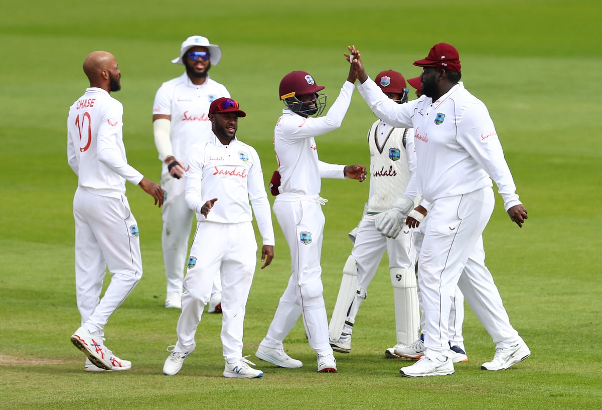 West Indies' Rakheem Cornwall celebrates taking a catch to dismiss England's Rory Burns off the bowling of West Indies' Roston Chase with teammates