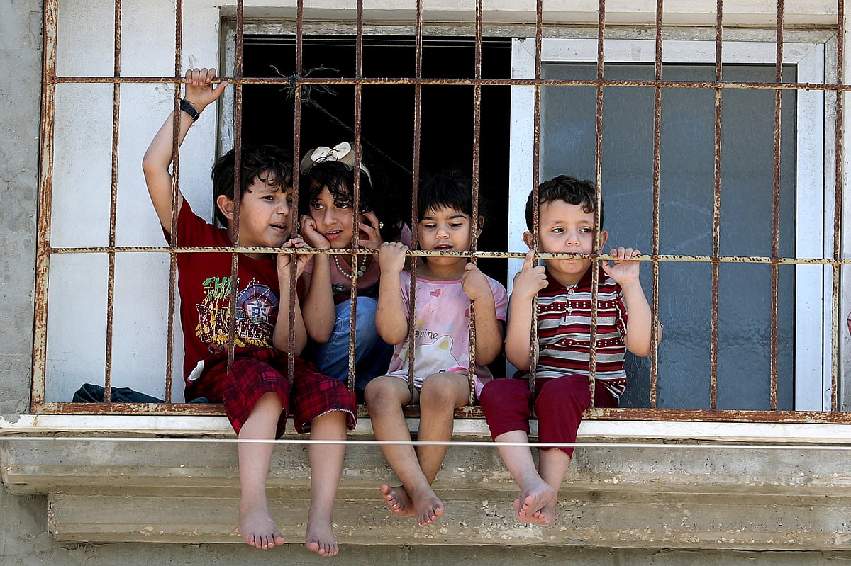 Children watch a rally through a home window fence as Palestinians call for a 'day of rage' to protest against Israel's plan to annex parts of the Israeli-occupied West Bank, in Gaza City, 1 July 2020.
